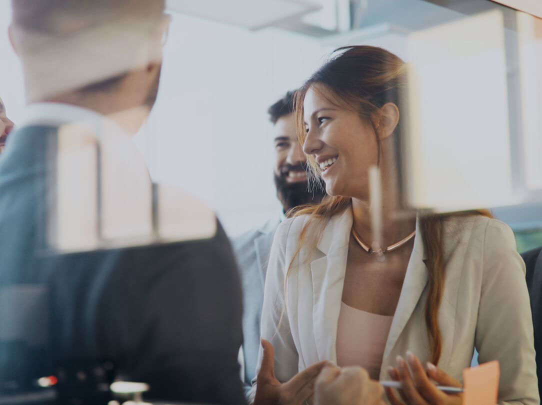 three cheerful people wearing suits in an office