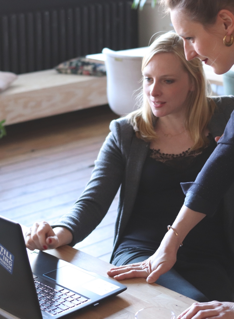 two people looking at a laptop