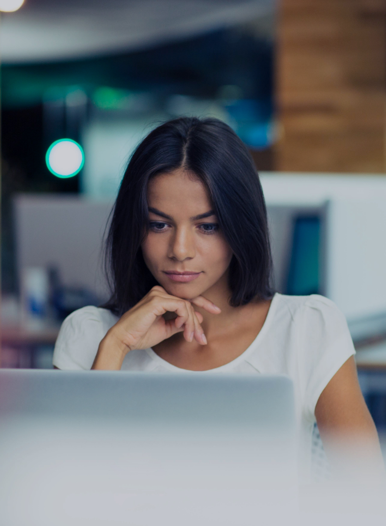 a smiling person looking at a laptop